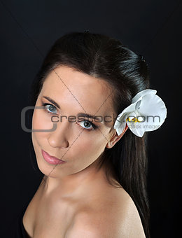 brunette woman with white orchid in hair