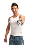 Cropped view of a muscular young man holding clock. It is time for workout concept.