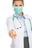 Medical doctor woman in mask showing syringe