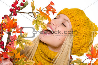 Happy girl in hat and scarf playing with autumn bouquet
