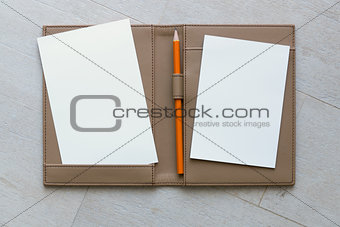 Paper and Pencil on Brown Leather Book