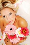 Beautyful young naked woman holding bunch of flowers
