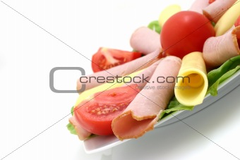 plate of cheese, pork and tomatos