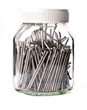 steel nails neatly stacked in a glass jar