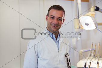 Portrait of happy caucasian dentist smiling at camera