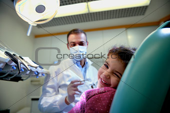 young girl lying on couch in dentist studio looking at camera