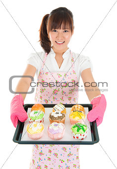 Young Asian female baking bread and cupcakes