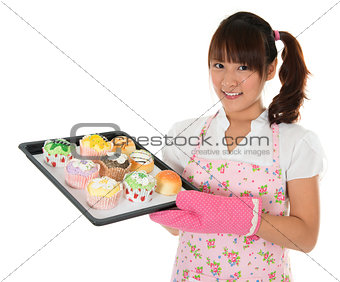 Young Asian girl baking bread and cupcakes