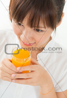 Asian female drinking orange