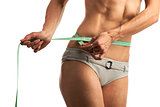 Cropped view of young fitness woman with measuring tape over white