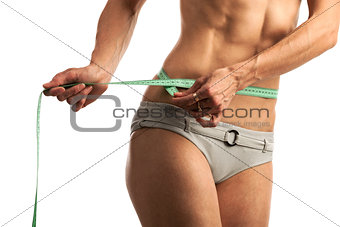 Cropped view of young fitness woman with measuring tape over white