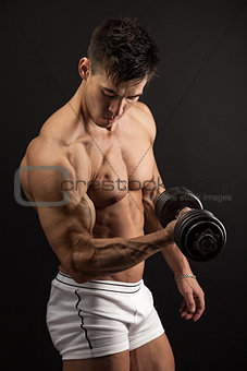 Muscular young man lifting a dumbbell