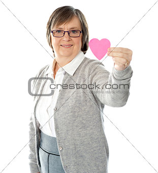 Female holding a pink paper heart