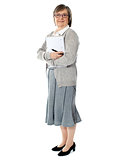 Full length portriat of an aged woman carrying business documents
