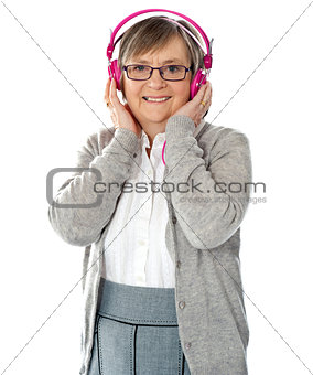 Attractive old lady wearing headphones