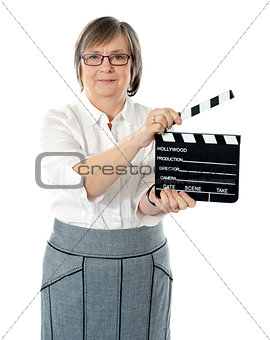Attractive senior woman using clapperboard