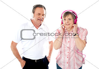 Happy aged couple enjoying music together
