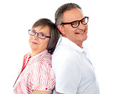 Portrait of smiling aged couple posing back to back