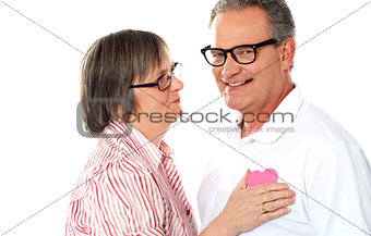 Senior couple with pink heart isolated on white