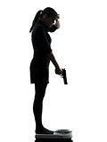woman standing on weight scale  despair aiming gun silhouette