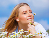 Cute female enjoying daisy smell