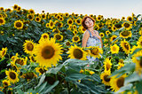 woman on blooming sunflower field