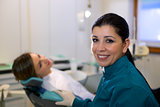 Portrait of woman and dentist in dental studio, looking at camer