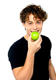 Young man eating fresh healthy green apple