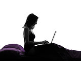  woman computing laptop computer in bed silhouette