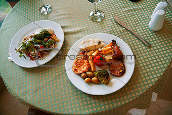 delicious meat and vegetable dishes on the table of restaurant