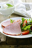 Baked sliced ham served with green salad