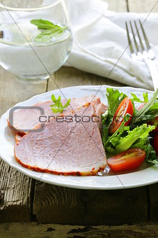 Baked sliced ham served with green salad