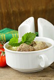 Soup with meatballs and vegetables in white bowl