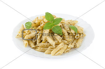 Pasta with pesto sauce and fresh basil on white plate