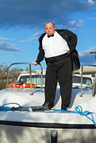 Fat man in tuxedo on deck boat