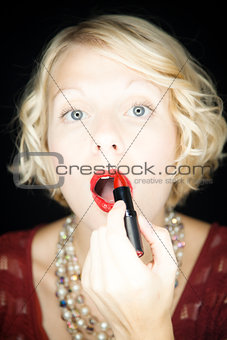 Lady putting lipstick - mouth open 