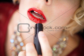 Lady putting lipstick - closeup 