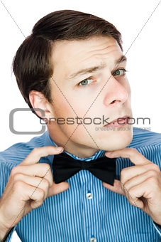 Handsome old-fashioned gentleman adjusting his bow tie 