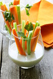 carrots and celery with dip in a glass beakers