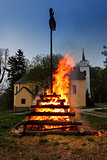big night fire with witch on pile behind the church