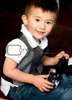 Happy Young Boy in Vest Plays Around With Vintage Camera