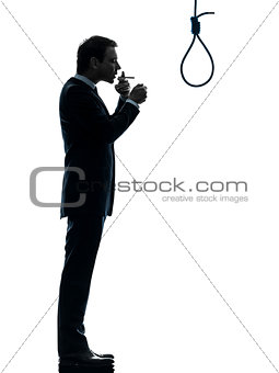 man smoking cigarette in front of  hangman noose silhouette