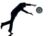 business man running after clock silhouette