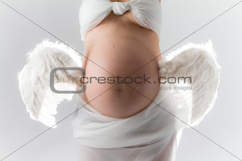 Pregnancy. Woman with wings attached to belly.