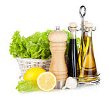 Lettuce in basket with lemon fruits, pepper shaker, olive oil an