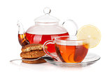 Glass cup and teapot of black tea with lemon and cookies