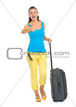 Full length portrait of happy young tourist woman with wheel bag
