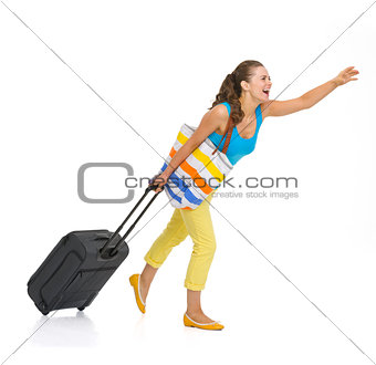 Full length portrait of young tourist woman with wheel bag catch
