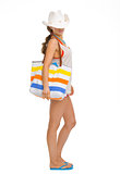 Full length portrait of young woman with beach bag