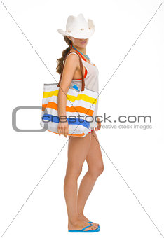 Full length portrait of young woman with beach bag
